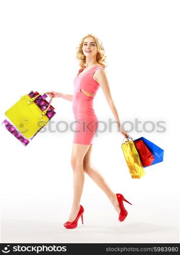 Slim blond woman holding a bunch of colorful bags