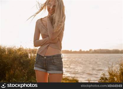 Slim body woman with long blond hair on summer beach retro colors backlit photo shot. Slim body woman with long blond hair on summer beach soft retro colors backlit photo shot.
