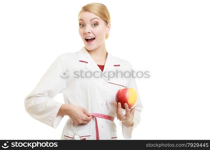 Slim down dieting concept. woman in white lab coat recommending healthy food. Doctor specialist dietitian holding fruit apple measuring her waist isolated.
