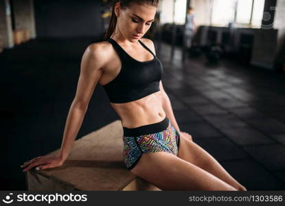 Slim female athlete trains press in sport gym. Young woman exercise in fitness club. Slim female athlete trains press in sport gym
