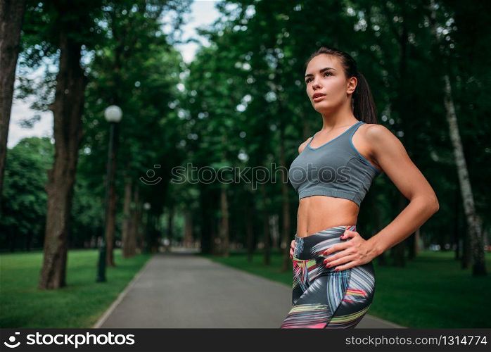 Slim girl in sportswear, outdoor fitness training. Athletic woman on workout in summer park