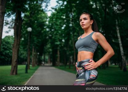 Slim girl in sportswear, outdoor fitness training. Athletic woman on workout in summer park