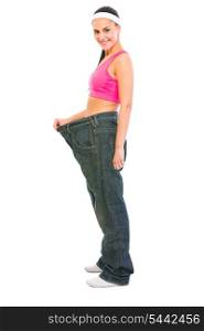 Slim girl pulling oversize jeans. Weight loss concept