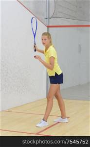 slim sportswoman standing in indoor tennis court