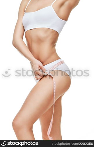 Slim tanned woman&rsquo;s body isolated on white background - waist measurement.. Slim tanned woman&rsquo;s body isolated on white background - waist measurement