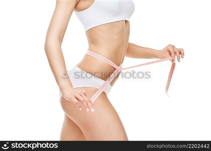Slim tanned woman&rsquo;s body isolated on white background - waist measurement.. Slim tanned woman&rsquo;s body isolated on white background - waist measurement
