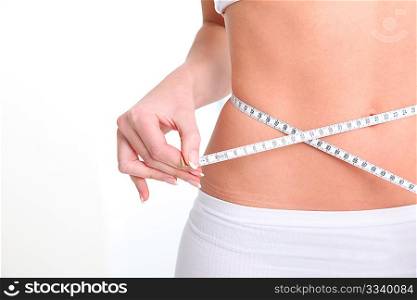 Slim woman&acute;s waist and measure tape