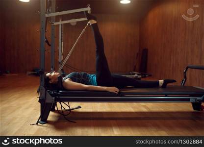 Slim woman in sportswear doing stretching pilates exercise in gym. Fitness workuot in sport club. Athletic female person, aerobics. Slim woman doing stretching pilates exercise