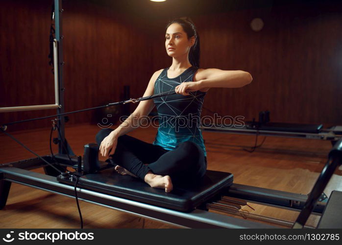 Slim woman in sportswear, pilates training on exercise machine in gym. Fitness workuot in sport club. Athletic female person, aerobics. Slim woman in sportswear, pilates training