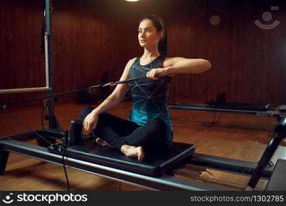 Slim woman in sportswear, pilates training on exercise machine in gym. Fitness workuot in sport club. Athletic female person, aerobics. Slim woman in sportswear, pilates training