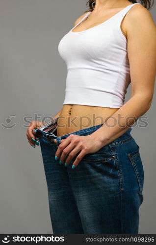 Slim woman trying on large size jeans