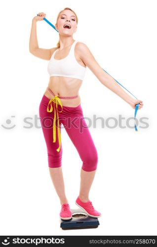 Slimming and weight loss. Happy joyful young woman girl measuring with tape measures on weighing scale. Healthy lifestyle concept. Isolated on white.. Happy woman measuring on weighing scale. Weight.