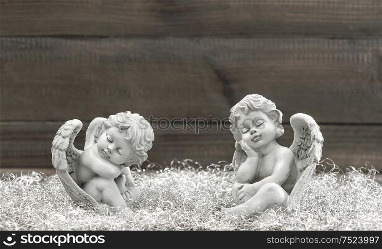 Slipping guardian angel with shiny christmas decoration over dark background