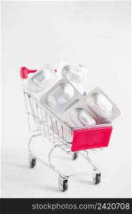 sliver blister pills miniature shopping cart white background