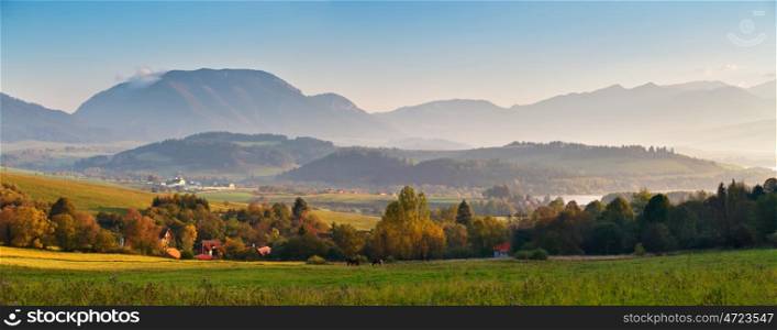 Slovakia autumn sunny morning panorama. Rural fall mountain scene. Village in valley.