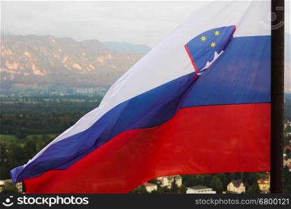 Slovenian national flag fluttering over Lake Bled and town. Slovenian national flag fluttering over Lake Bled