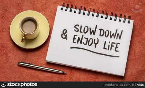 slow down and enjoy life - inspirational handwriting in a sketchbook with a cup of coffee, work life balance and lifestyle concept