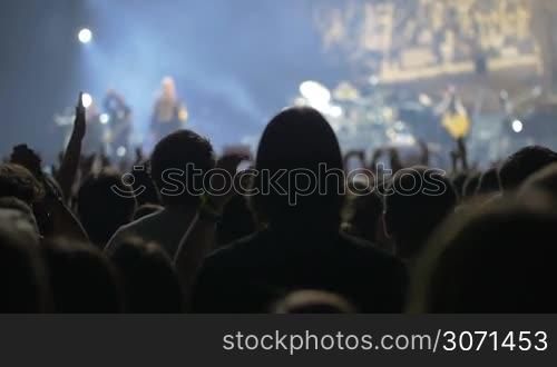 Slow motion clip of people standing back and greeting the star on the stage by clapping their hands