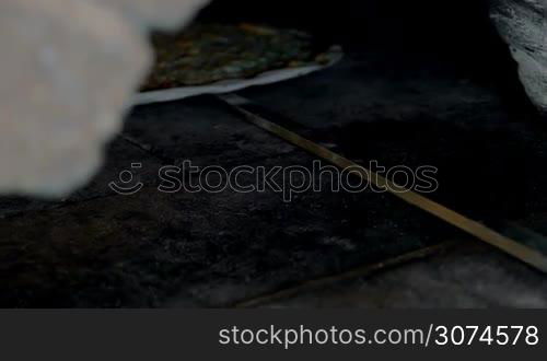 Slow motion close-up shot of getting tasty cheese pizza from the hot oven with spatula