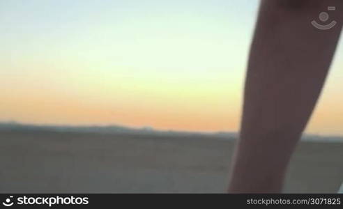 Slow motion close-up shot of man and woman taking hands on background of evening sky. Symbol of love and devotion