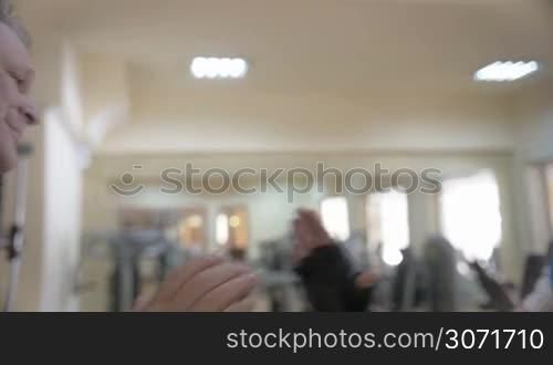 Slow motion close-up shot of two strong men having a firm handshake after training in the gym. Teamwork and friendship