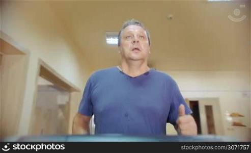 Slow motion of a man using treadmill in the gym. Regular physical activity is necessary for people of all ages