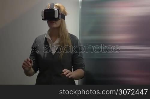 Slow motion of a woman having adventure in virtual world. She using augmented reality headset creating virtual space based on smartphone applications