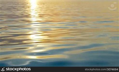 Slow motion of sea water with slight ripple sparkling in light of sunset. Water surface background with golden path of evening sun reflection