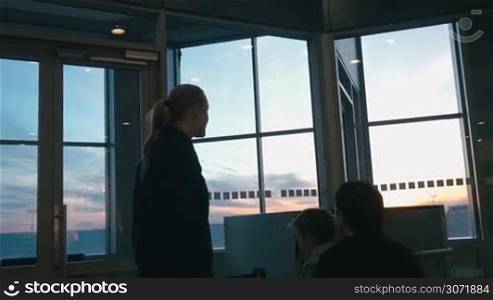 Slow motion of young parents and little son by the window at the airport. Father putting child on the shoulder to show him the planes. They looking out the window and pointing at something