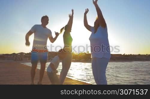 Slow motion shot of a family doing morning exercises on a sea pier.