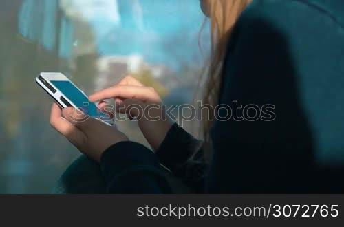 Slow motion shot of a smartphone in female hands. Woman is writing a message on it.