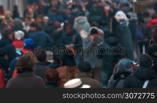 Slow motion shot of city people walking outdoor in cold day. Shot is made with slight defocus.