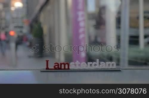 Slow motion shot of traveling by bus or tram in Amsterdam. View to the streets with people through the window with city slogan, Netherlands