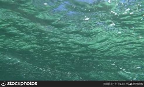 Slow motion shot of wavy sea surface made underwater.
