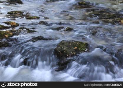 Slow river with rocky path and milky like water