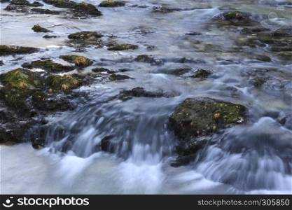 Slow river with rocky path and milky like water