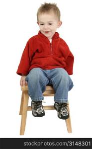 Small 1 year old boy sitting on a wooden step stool. Shot over white.