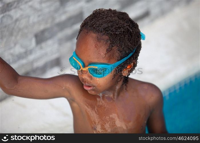 Small African American child with goggles in the pool