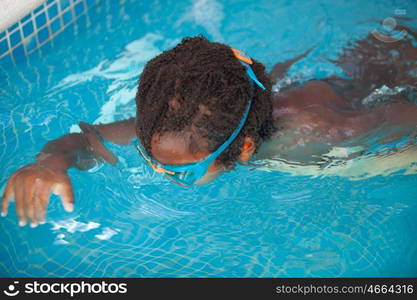 Small African American child with goggles in the pool