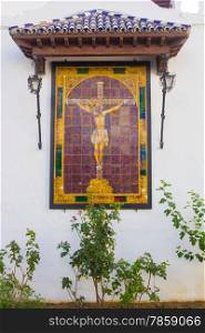 small altar with a Christ Andalusian tiles on a white wall