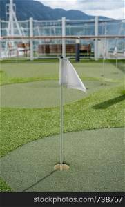 Small artificial putting green for golf practice on the deck of a cruise ship. Mini golf on the deck of a cruise ship