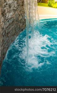 Small artificial waterfall in the swimming pool