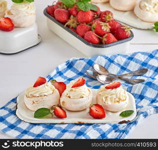 small baked round cake meringue with whipped cream and strawberry