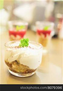 Small banoffee cup with blurred of other desserts background