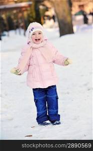 small beautiful girl playing in park. winter day