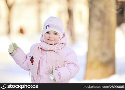 small beautiful girl playing in park. winter day