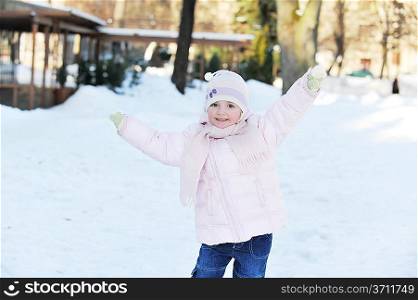 small beautiful girl playing in park. winter day