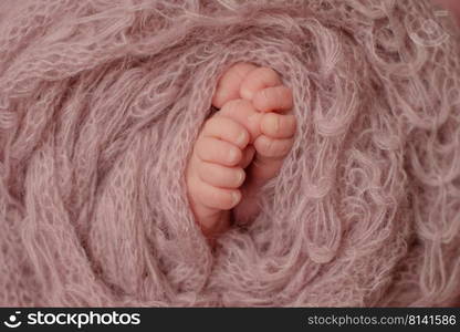 Small beautiful legs of a newborn baby in the first days of life. Baby feet of a newborn. Small beautiful legs of a newborn baby in the first days of life