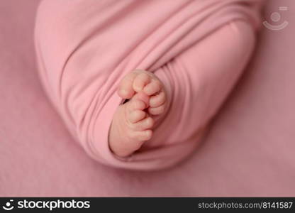 Small beautiful legs of a newborn baby in the first days of life. Baby feet of a newborn. Small beautiful legs of a newborn baby in the first days of life