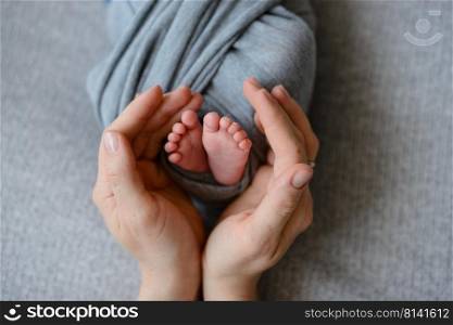 Small beautiful legs of a newborn baby in the first days of life. Baby feet of a newborn. Small beautiful legs of a newborn baby in the first days of life
